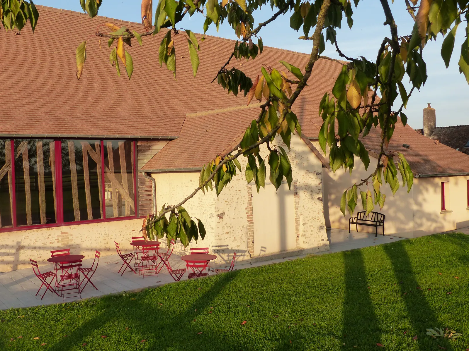 La façade en pierre et la terrasse sous le grand noyer