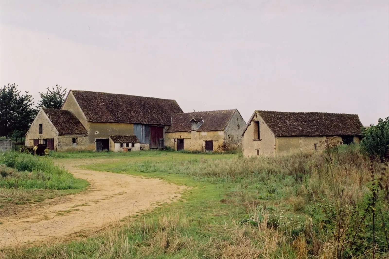 La cour de la ferme du Pontaubeau et ses bâtiments de pierre avant la restauration