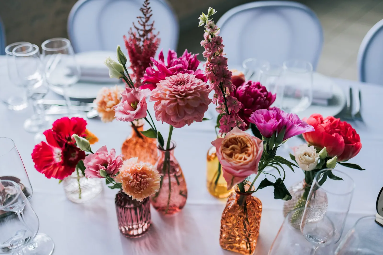 Un bouquet de dahlias et de roses sur une table de mariage