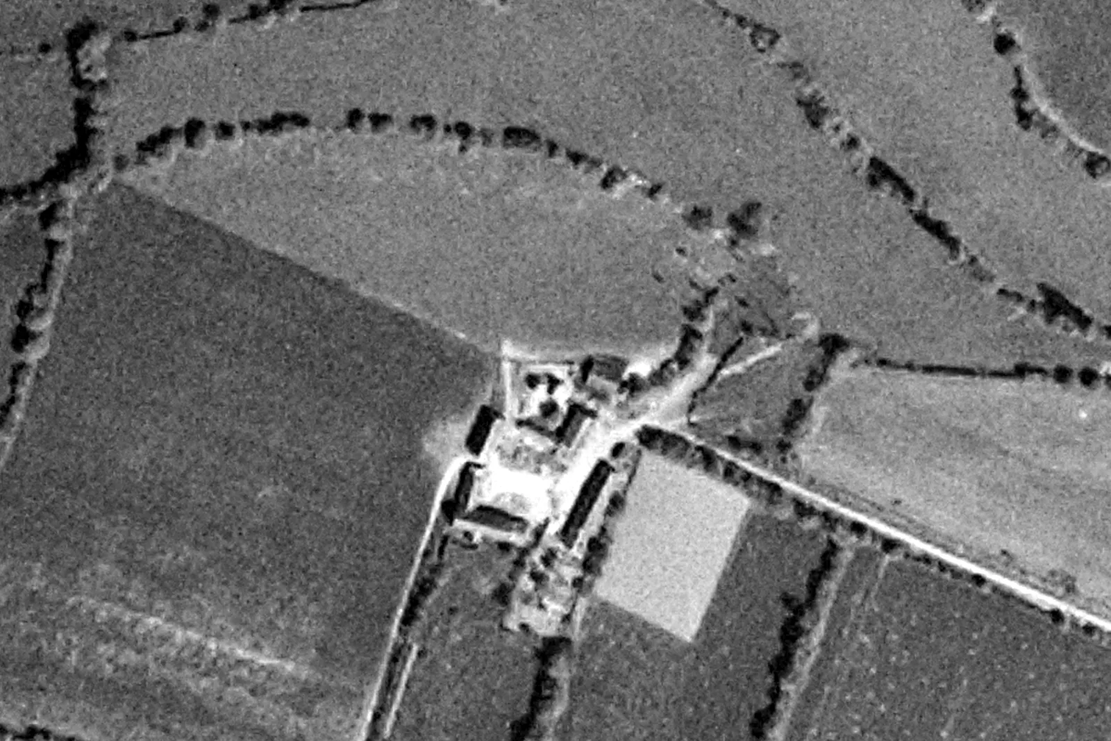 Photographie aérienne en noir et blanc : la ferme du Pontaubeau au milieu des prés et des haies