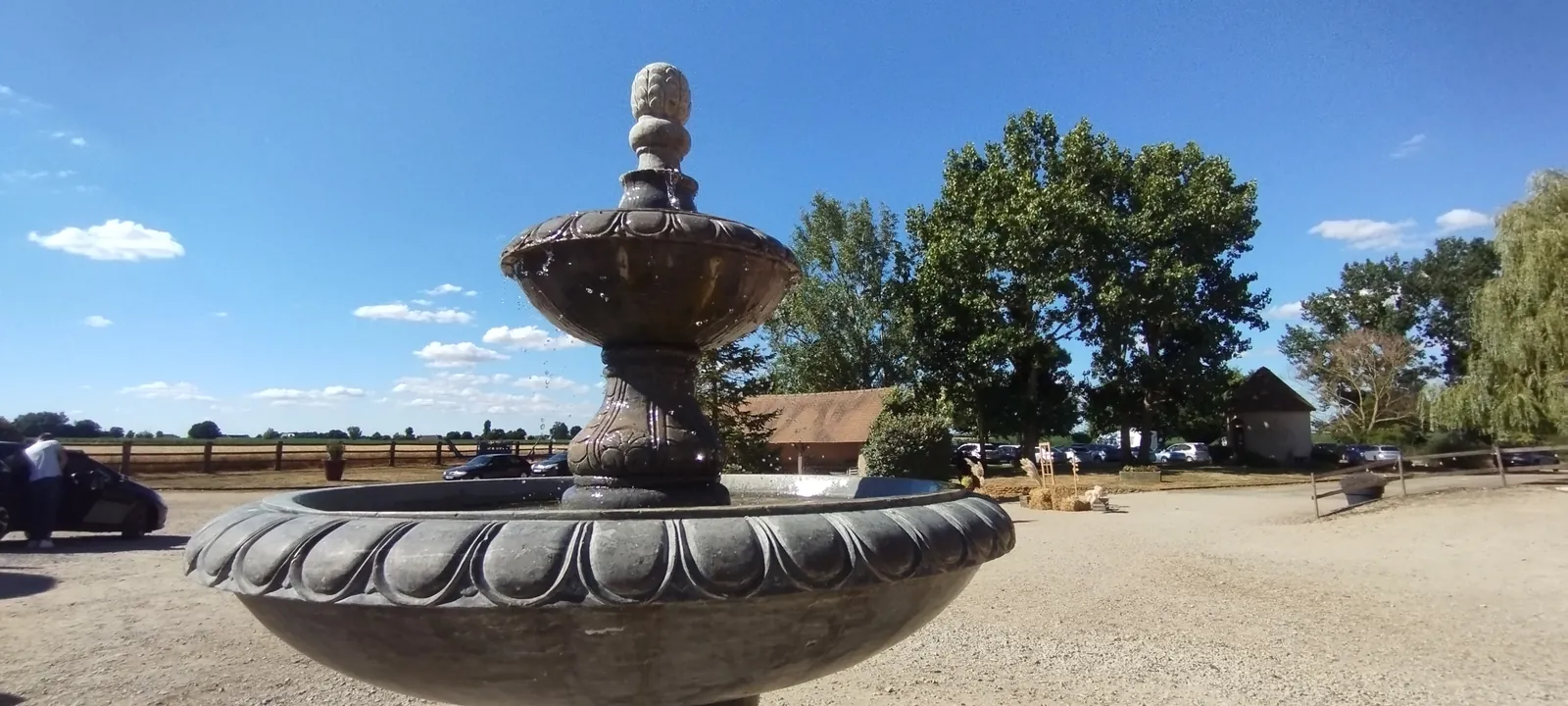 La fontaine de la cour, avec la plaine à perte de vue