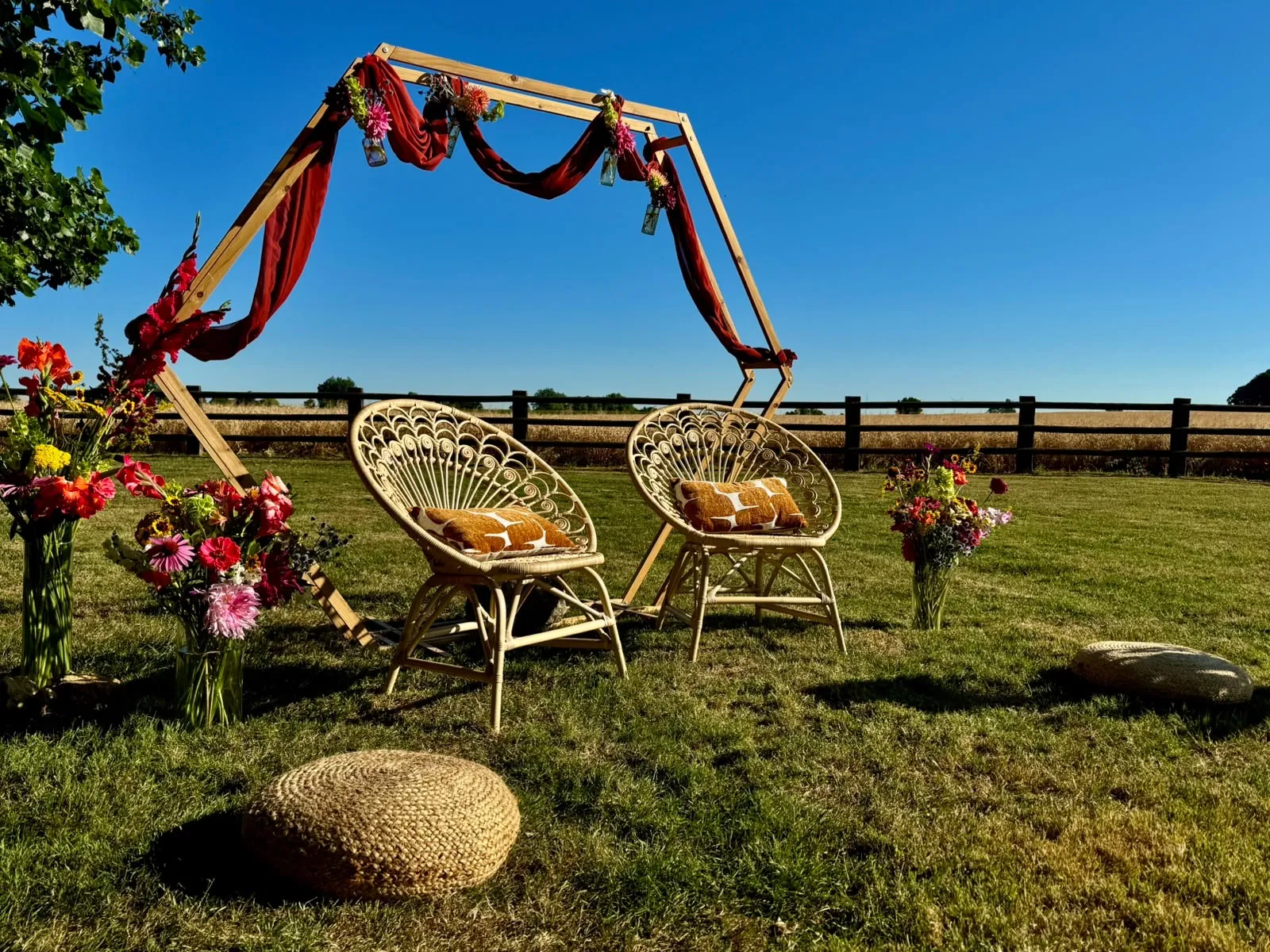 Arche de cérémonie et fauteuils en rotin sur la pelouse